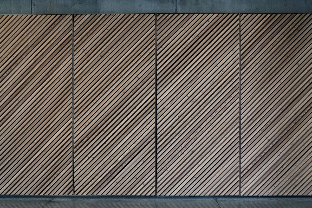 Abstract view of a diagonal wooden panel wall with a textured, patterned design.