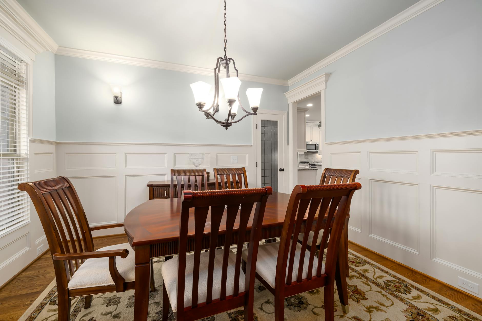 A beautifully designed dining room featuring classic wooden furniture and elegant lighting.