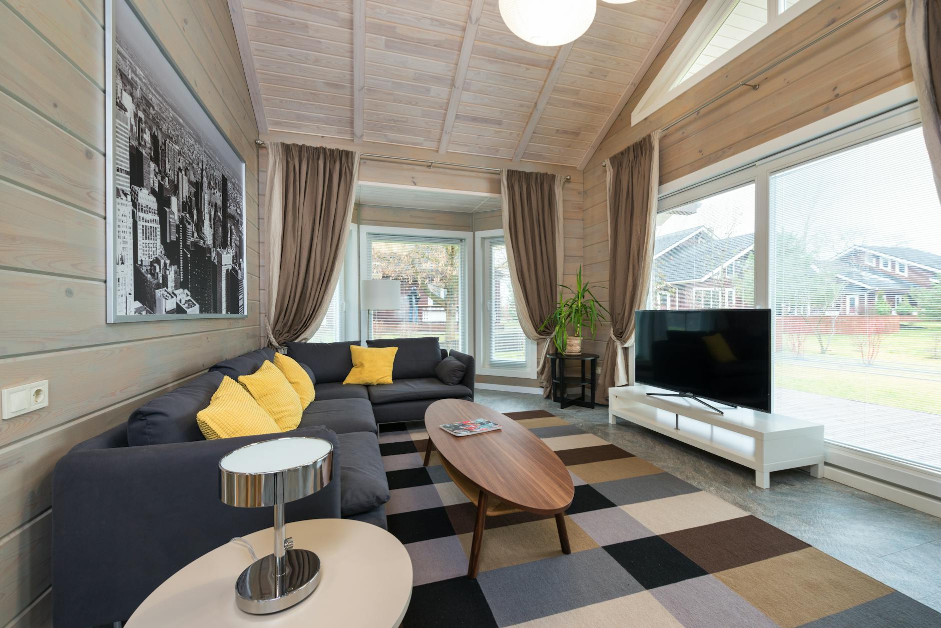 Bright and airy Scandinavian-style living room featuring sleek furniture and large windows.