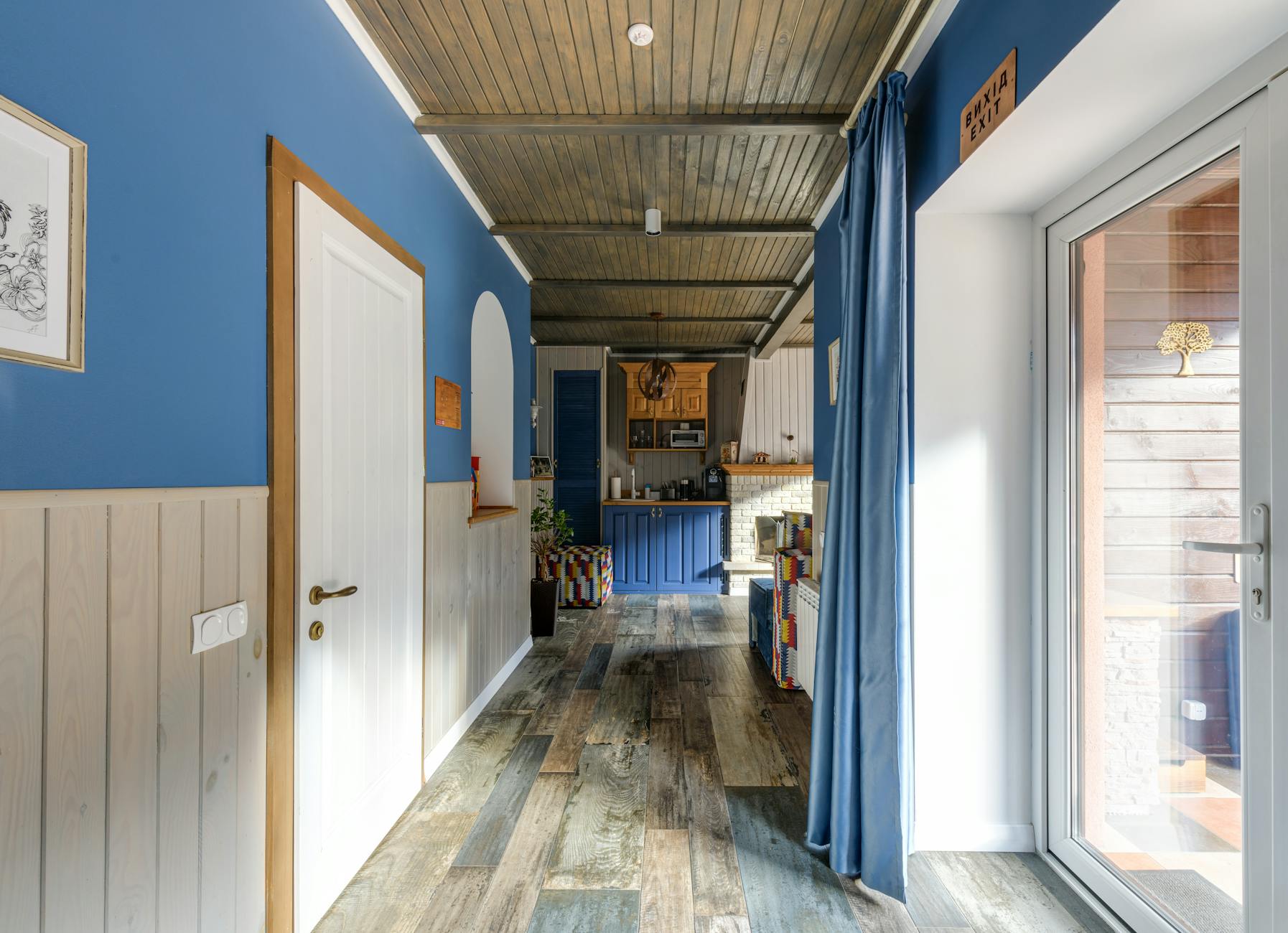Elegant hallway showcasing contemporary blue decor and wooden flooring.