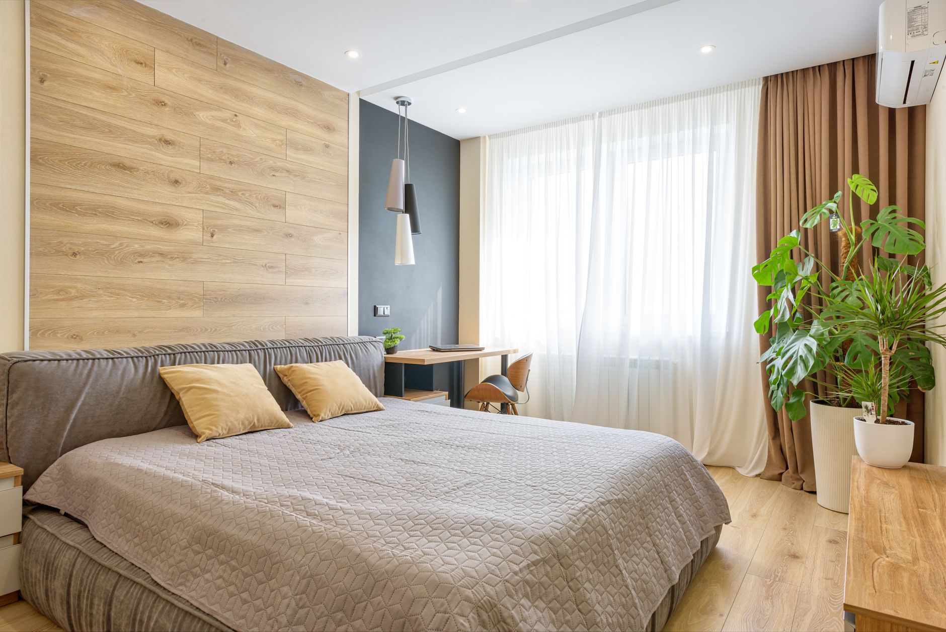 Bright modern bedroom with wooden accents, natural light, and cozy decor.