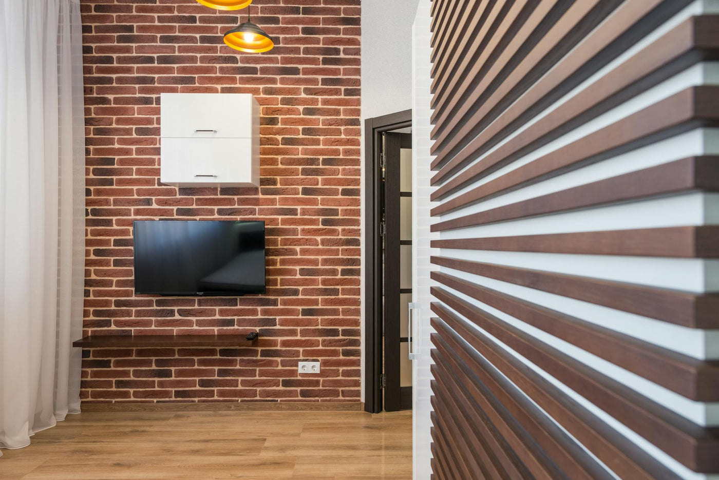 Stylish interior with brick wall, mounted TV, and wooden details for a modern home design.