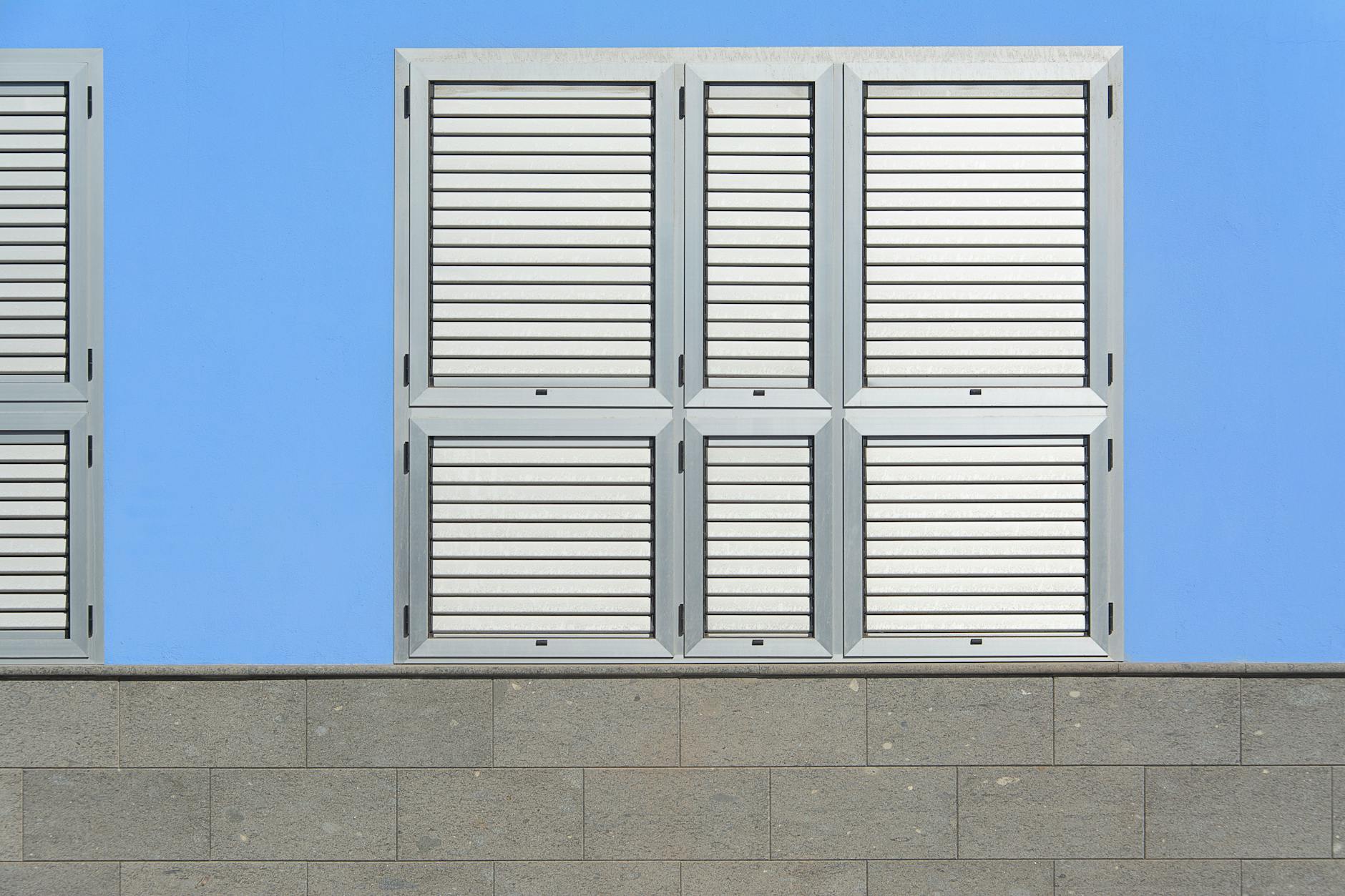 Clean and simple design of a blue wall featuring aluminum shutters, ideal for architectural themes.