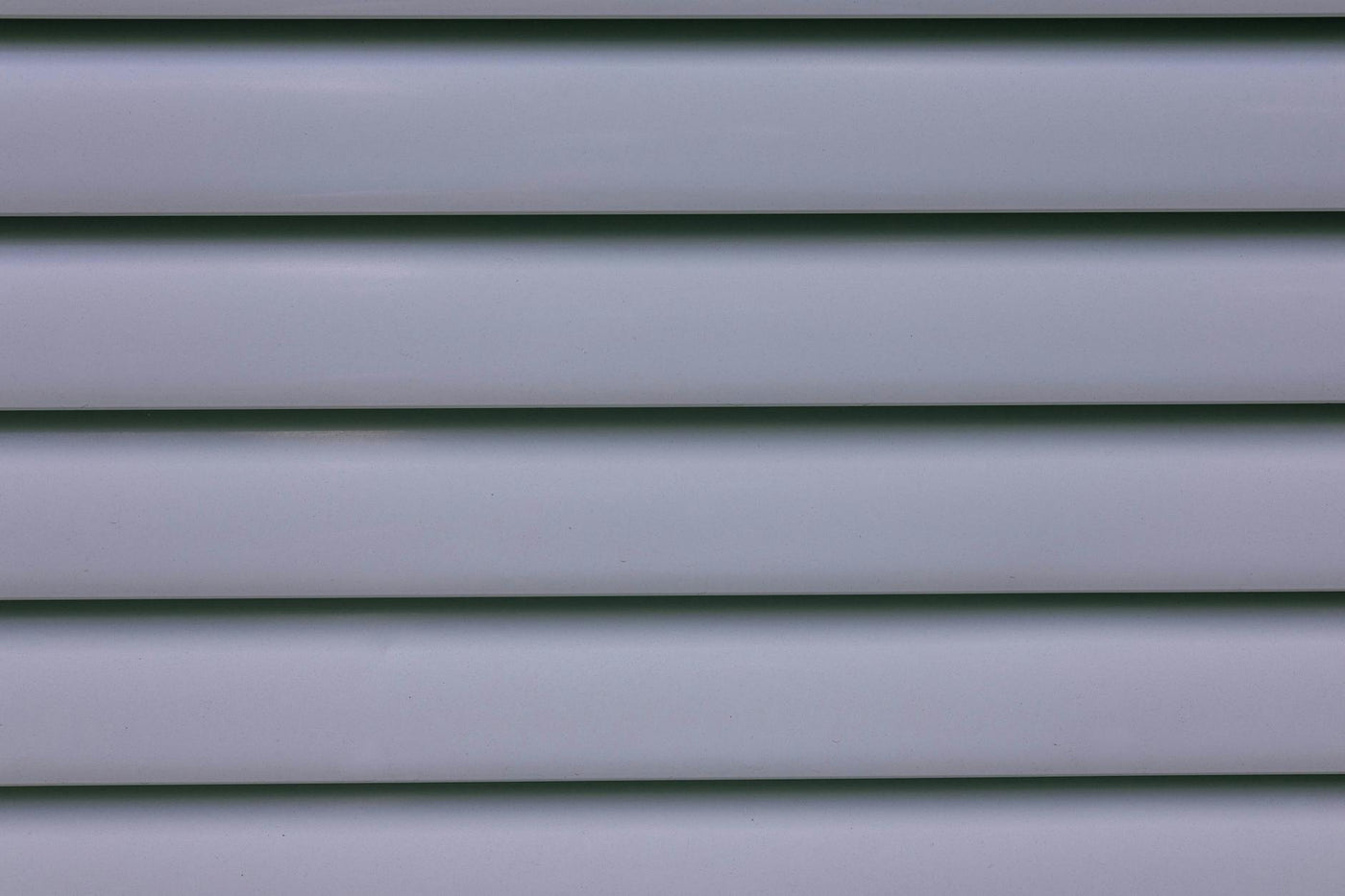 Detailed close-up of gray layered wall paneling showing lines and shadows.
