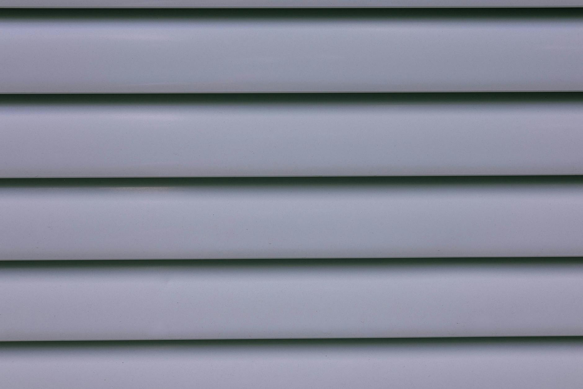 Detailed close-up of gray layered wall paneling showing lines and shadows.