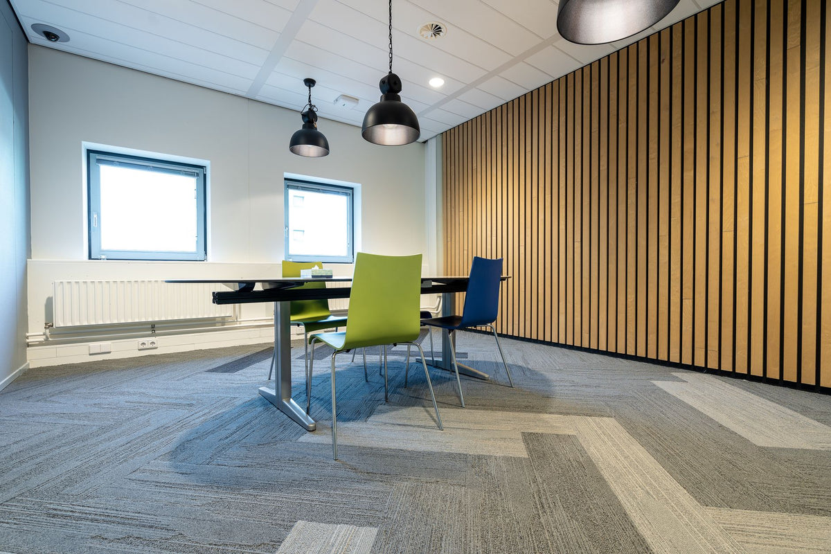 Spacious meeting room with colorful chairs and modern lighting in a corporate setting.