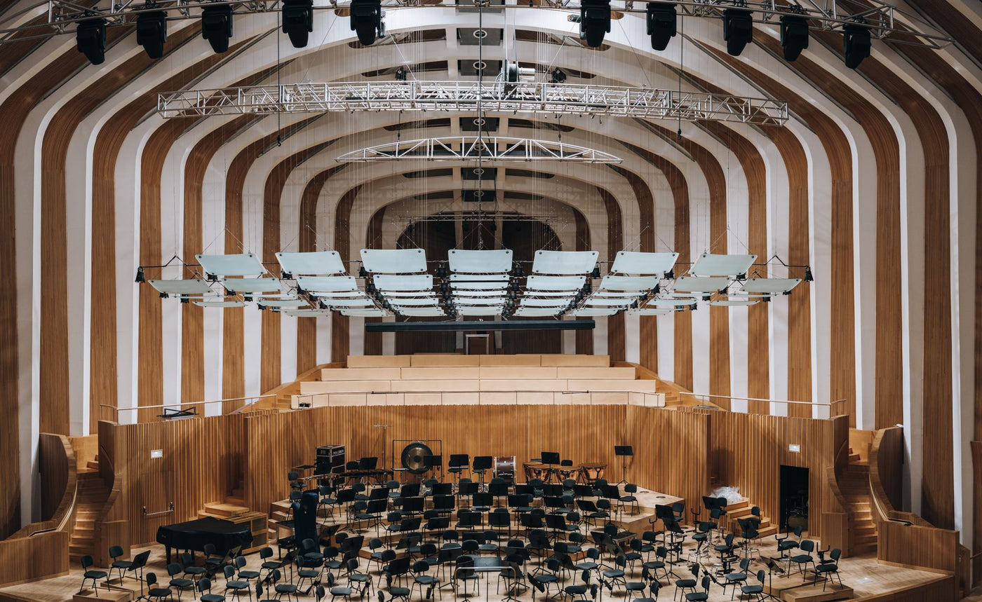 Spacious modern auditorium featuring wooden interior architecture and empty seating.